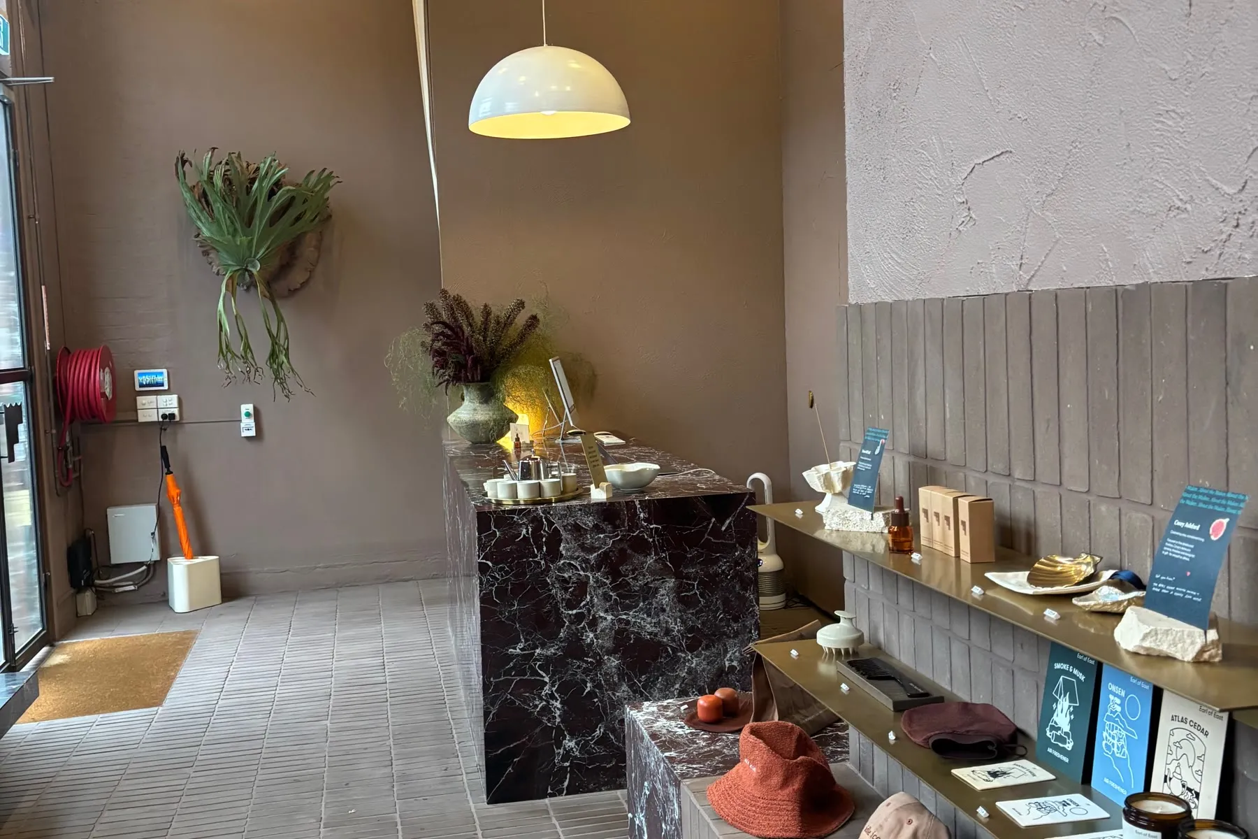 Recepção do Sense of Self em Collingwood, com mármore vermelho, prateleiras e paredes texturizadas
